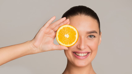 Detox concept. Woman holding piece of orange