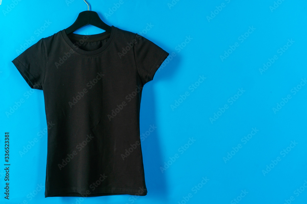 Wall mural Black plain t-shirt hanging on a hanger, copy space