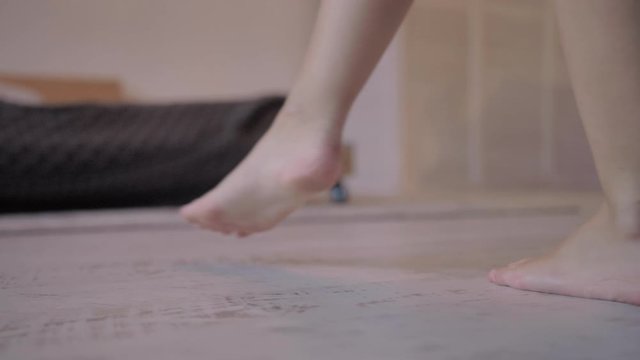 Female legs bare closeup walking on the floor