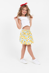 Naklejka premium attractive teenager girl in a white T-shirt and skirt flirts in full growth on a white background with copy space