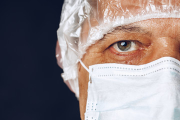 Male doctor wearing protective Mask and Goggles. Dark background. Close up