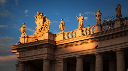 Panoramic detail of the statues of saints in Saint Peters Square with a warm light of a summer afternoon. Città del Vaticano, Italy.