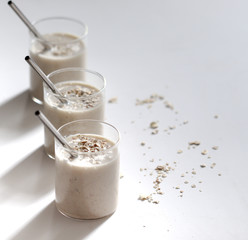 Smoothie banana and oatmeal in glass on a light  gray background 