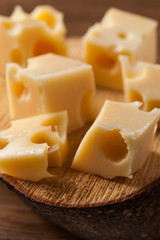 Pedaços de queijo amarelo sobre uma tábua de madeira