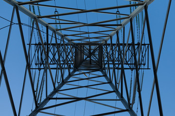 Abstract geometric pattern created by interweaving elements of the frame of the power line support tower.