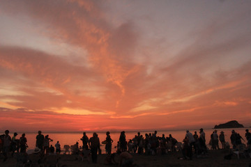 Fototapeta premium silueta de personas bajo un bello atardecer rojizo