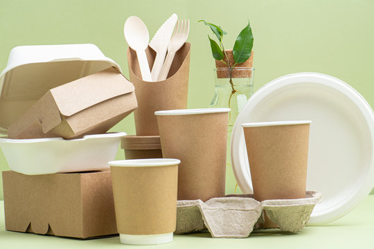Side view on eco-friendly disposable containers for food and drinks over green