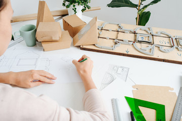 Close shot of a box maker working behind a desk, from behind.