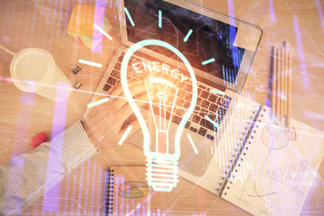 Double exposure of man's hands typing over computer keyboard and bulb hologram drawing. Top view. Idea concept.