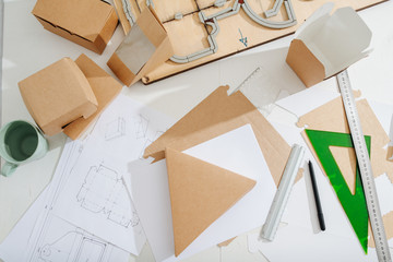 Workplace of a box maker, sheets, tools and scematics all across