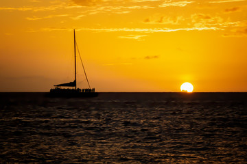 People in Silhouette on Boat Watch Sun Drop Below Horizon