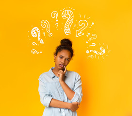 Puzzled pensive young african american teen girl with question marks