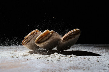 pancakes made of dough in flour on a dark background close up
