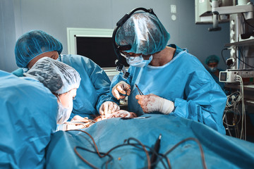 A team of professional surgeons works in the operating room. A real operation to remove a cancerous...