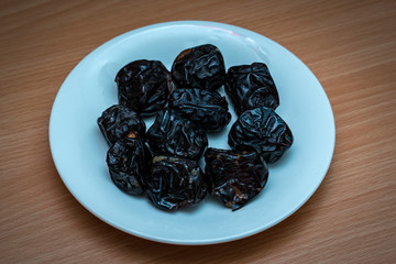 Ramadan food and drinks concept. Dates fruit in a bowl on wooden table background.