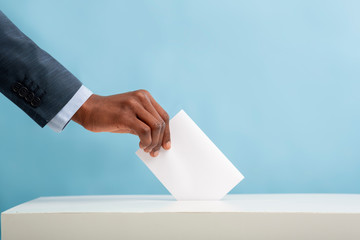 African american man putting an empty ballot in election box