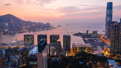 Aerial scenery panoramic view of Hong Kong Evening with metropolitan bay Victoria Harbor at sunset. Lighted Modern cityscape, urban skyline buildings. Energy power infrastructure. Popular Asian city
