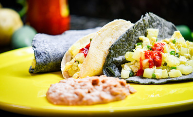 Potatoes with eggs tacos made with white and blue corn tortilla