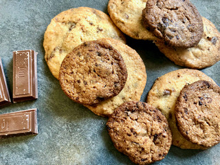 Top view of a pack of homemade chocolate chip cookies with 10gr. chocolate bars aside.