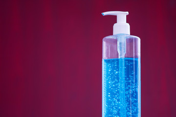 Hand sanitizer pump bottle, washing gel, alcohol gel. Alcohol gel for hand wash on red background. Protection against pollution, virus, flu and coronavirus. Healthcare and medical concept. Copy space