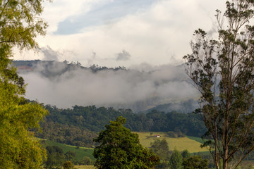 Fototapeta na wymiar Early in the morning low clouds cover with mist the central Andean mountains in the department of Boyaca in Colombia