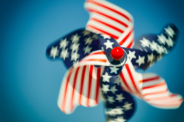 American flag pinwheel with stars and stripes in patriotic red, white and blue spinning in the wind in sunny sky