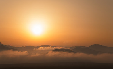 Landscape of sunset over the mountains and fog
