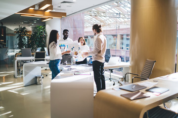 Successful male and female colleagues collaborating in office interior discussing progressive ideas for business project and marketing plan, concept of entrepreneurship and brainstorming discussion