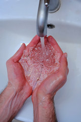 Fototapeta premium Hygiene concept. Washing hands with soap under the tap with water. Handsome male hands and water in the bathroom. Preventive of Covid-19