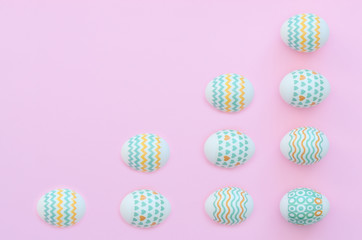 Decorated Easter eggs lie on the pink background. Happy Easter holiday concept. Greeting, invitation card. Flat lay style with copy space.