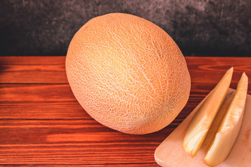Melon on wooden table with black background