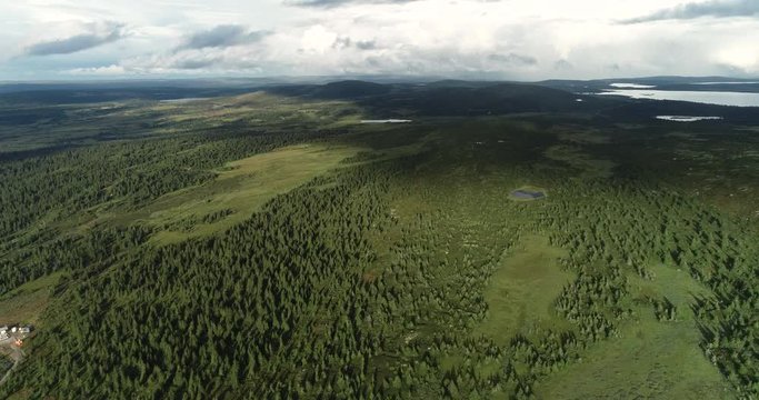 Spectacular aerial view of forest and lakes on flat pane of oyer. Drone fles towards meteorological tower.