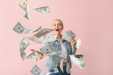 Beautiful young woman with flying money on color background