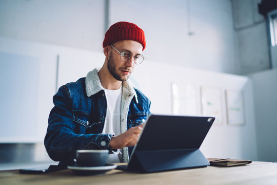 Young hipster man using modern tablet in cafe