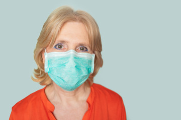 Older woman with face mask looking directly in camera  