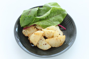 Potato and anchovy stir fried served with baby leaves