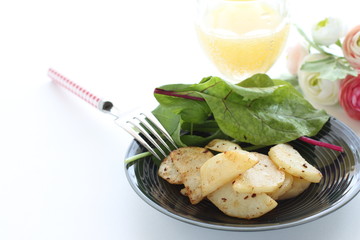 Potato and anchovy stir fried served with baby leaves
