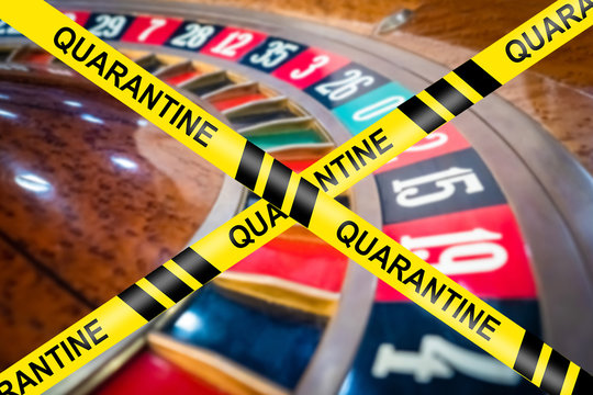 Closing a quarantine casino. Tape quarantine on the background of the roulette table. Concept - the work of gambling establishments is suspended. Closing quarantine entertainment venues.