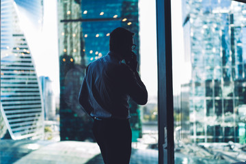 Faceless manager talking to colleague on phone in office