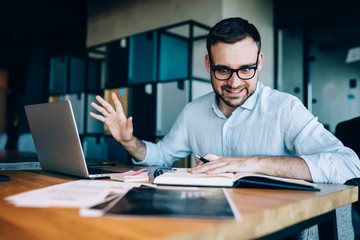 Angry male investor in optical eyewear reading report information in textbook and feeling stress...