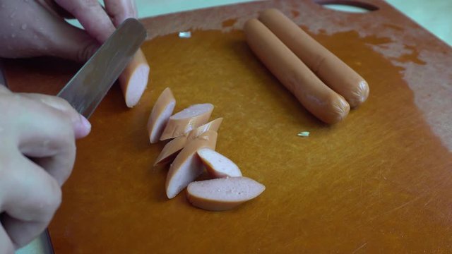 Lady hand slices fresh sausage