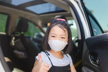 Coronavirus Covid-19 concept.Little chinese girl wearing face mask protect from virus and ok finger hands gesture for good.China lifts 76-day lockdown on Wuhan city reemerges from coronavirus crisis.