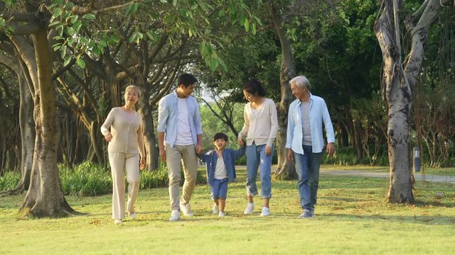 happy multi generation asian family having a good time walking in park