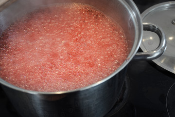 Making jam in a large pot, liquid boiling on the stove