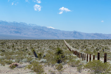 Thick wooden railroad tie beams and steel cable combined into Vehicle Barrier Fencing along the...