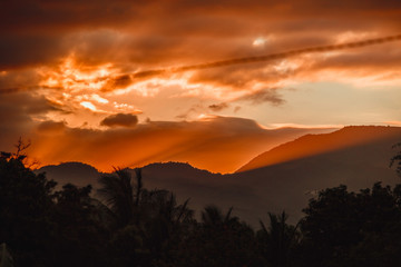 Fiery orange rays of sunset in the mountains