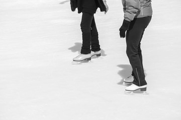 Fototapeta na wymiar Two women skating on ice in black and white