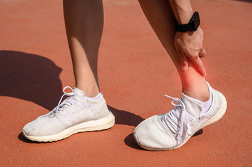 Cropped shot of woman runner suffering from ankle pain. Ankle pain may be caused by an injury, like a sprain, or by a medical condition, such as arthritis.