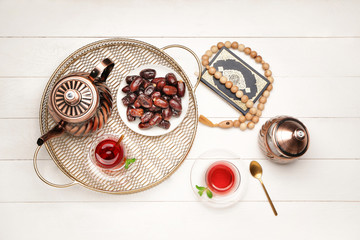 Tasty Turkish tea with dates, Koran and tasbih on table