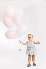 Little cute girl hold menu pink and white balloons enjoy festive  birthday event wear grey pastel summer dress rabbit-footwear isolated on a white background.